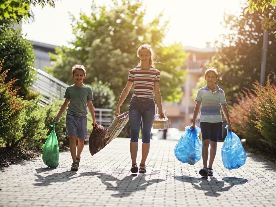 3 mensen wandelen met afvalzakken